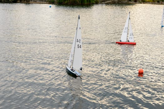 miniature sail boats racing in sea pond at touristic sea village .