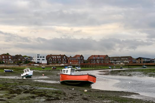 view of old boats aground at low tide time in the touristic sea village.