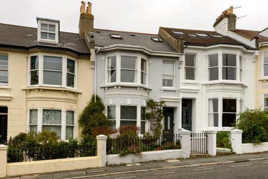 view of a row of old houses on an uphill street in touristic sea town,  Brighton, East Sussex.