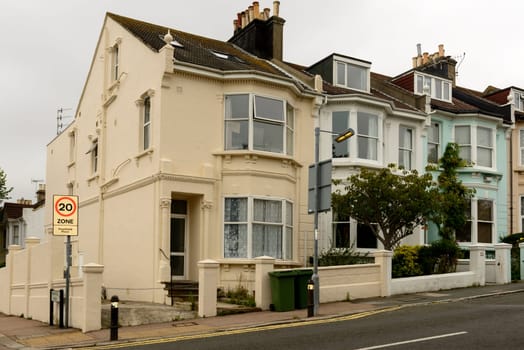 view of a row of old houses on an uphill street in touristic sea town,  Brighton, East Sussex.