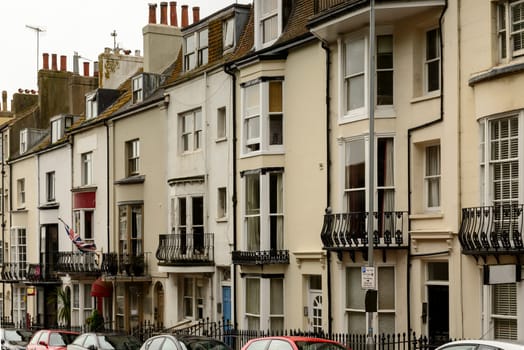 foreshortening of a row of old houses on an uphill street in touristic sea town,  Brighton, East Sussex.