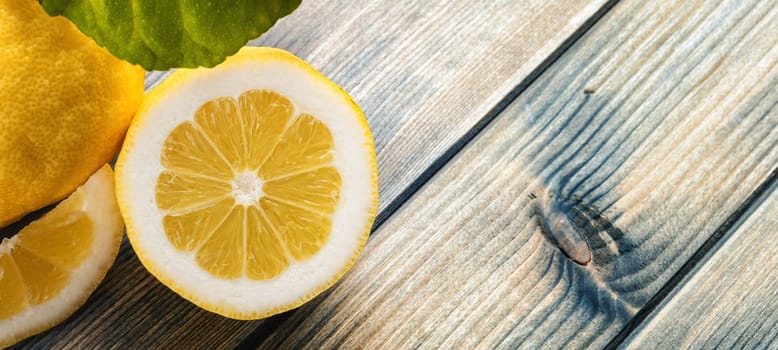Closeup of ripe lemons with leaves on an old wooden table. Healthy nutrition. Health.