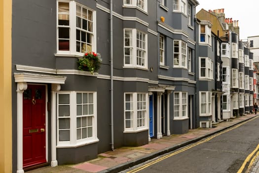 foreshortening of facades of old houses on a street in touristic sea town,  Brighton, East Sussex.