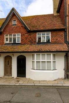 view of old house with traditional shingle roof on a street in the historic village of Hastings, East Sussex .