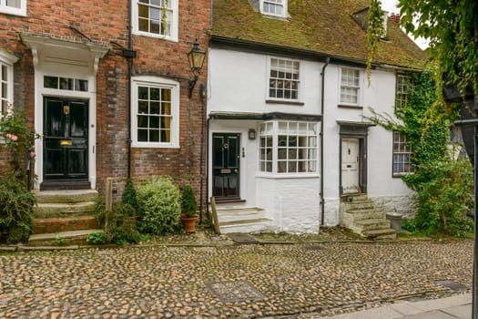 view of old brick houses on a cobbled street in the historic village of Rye, East Sussex .