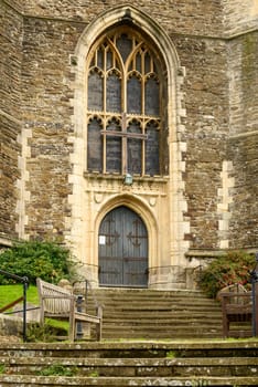 foreshortening with a bench on the stairs of the entrance of stone church  in the historic village of Hastings, East Sussex .