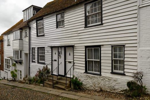 view of old houses on a uphill street in the historic village of Rye, East Sussex .