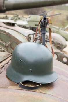 German helmet and  submachine gun on the armor of the tank