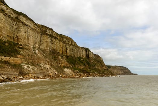 landscape of coastline with steep cliffs at historic village of Hastings, East Sussex .