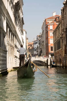Venice, Italy, March 30, 2014: The gondolier floats on a gondola with tourists