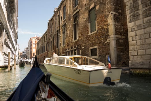 Venice, Italy- March 30, 2014:Captain leads the boat and the gondolier is transporting tourists on the street