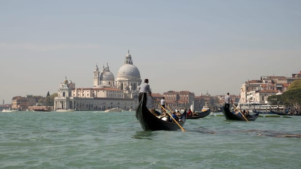 Venice, Italy, March 30, 2014: The gondoliers floats on a gondolas with tourists