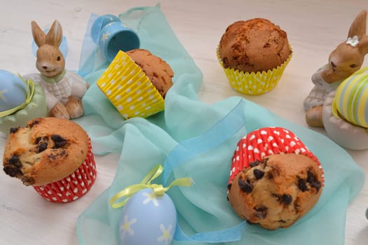 Easter decoration colored eggs, muffins and bunny on wooden table