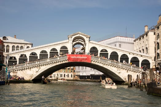 VENICE,ITALY-MARCH 30-Ships sailing under the bridge Rialto with walking tourists  in March 30,2014 in Venice