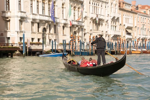 Venice, Italy- March 30, 2014: The gondolier floats on a gondola with tourists