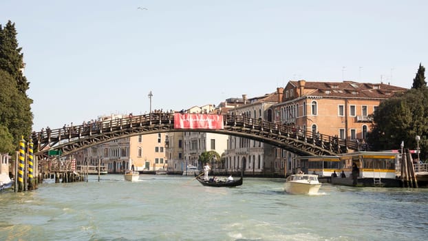 VENICE,ITALY-MARCH 30-Ships sailing under the bridge with walking tourists  in March 30,2014 in Venice