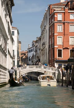 Venice, Italy- March 30, 2014:Ships sailing under the bridge with walking tourists