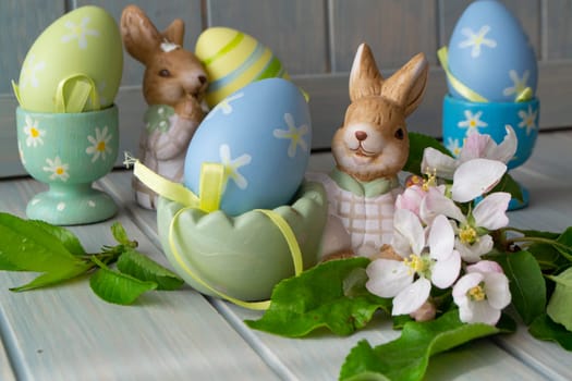 Easter decoration with rabbits, colorful eggs and flowers.