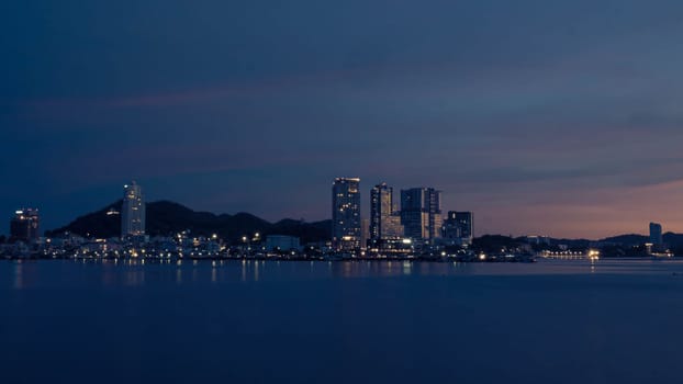 Panorama scenic of seascape with building on background and small mountain at dusk in Sriracha Chonburi Thailand