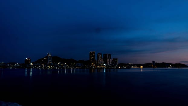 Panorama scenic of seascape with building on background and small mountain at dusk in Sriracha Chonburi Thailand