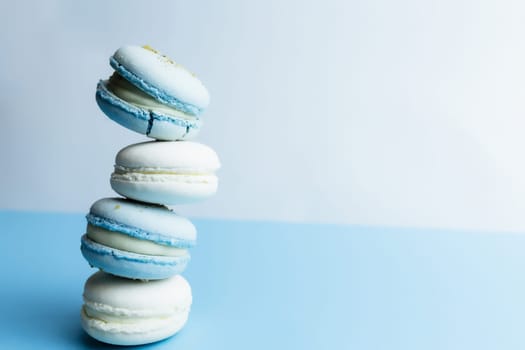 White and blue macaroons on the table, macaroons on white blue background. High quality photo