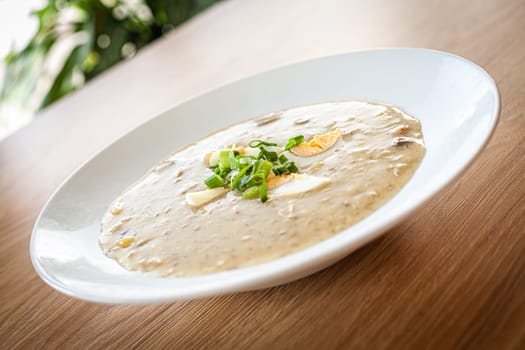 Cooked food on a white plate - dill soup with egg .
