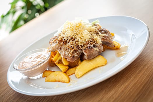 Cooked food on a white plate - pork chop with grated horseradish.