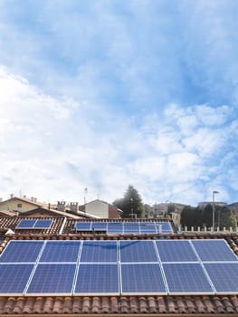 Solar panel on a red roof. Renewable energy source. Present technology. Vertical copy space on sky background.