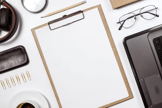 Flat lay of stylish male workplace with clip folder, laptop and business accessories on white background. Copy space