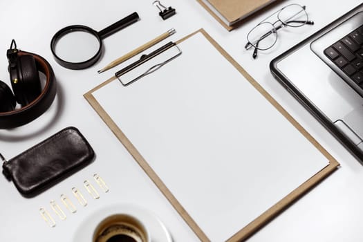 Flat lay of stylish male workplace with clip folder, laptop and business accessories on white background. Copy space