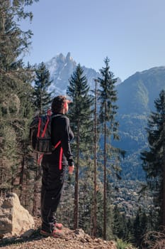 A young woman is hiking in the mountains near a ski resort town of Chamonix in France