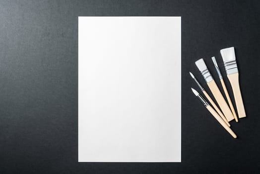 The sheet is pure white and the paint brushes are on a black background with a place to copy. Mock-up, mockup, layout.