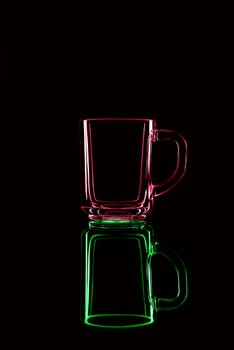 Just a glass on a black background with a reflection. Red and green. Isolated.