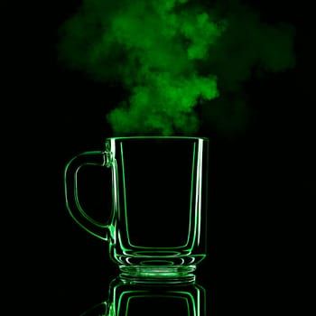 Just a glass on a black background with a reflection. Green color, with steam. Isolated.