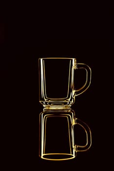 Just a glass on a black background with a reflection. Yellow colors. Isolated.