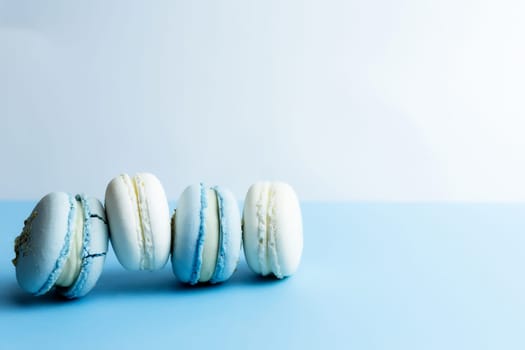 White and blue macaroons on the table, macaroons on white blue background. High quality photo