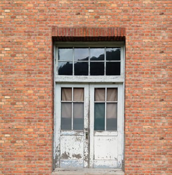 The White window at vintage red brick wall.