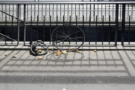 Bike theft in the city. Bicycle wheel and anti-theft device attached to a grid. (Paris, France)