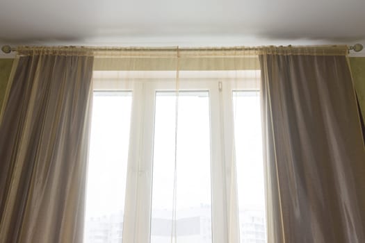 Curtains and tulle curtains large plastic windows in the apartment, close-up