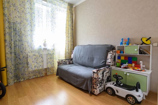 Anapa, Russia - March 1, 2021: Interior of a small modest children's room with a sofa and toys