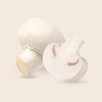 Perfectly retouched whole and half champignon mushrooms isolated on the white background with clipping path. Cultivated bisporus. Organic mushroom macro studio photo. Full depth of field.