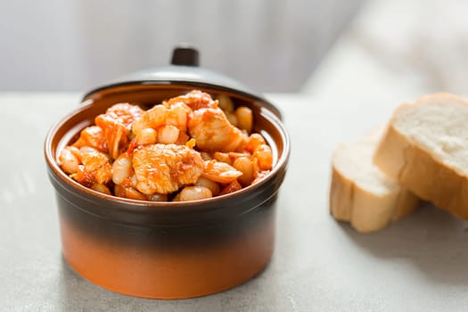 Steamed white beans with meat in tomato sauce. Homemade food concept. Close up. Selective focus.