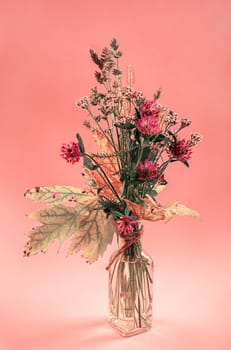 autumn flowers in a glass pitcher as table decoration on colored tablecloths