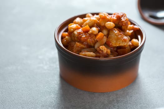 Steamed white beans with meat in tomato sauce. Homemade food concept. Close up. Selective focus.