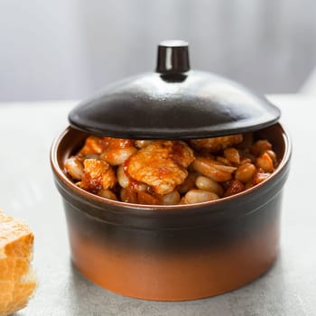 Steamed white beans with meat in tomato sauce. Homemade food concept. Close up. Selective focus.