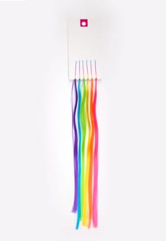 Artificial colored strands of hanging on a paper label with hairpins ready to use.