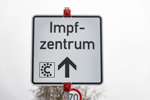 Street sign with german word for covid-19 vaccination center or center - vaccination center individually .