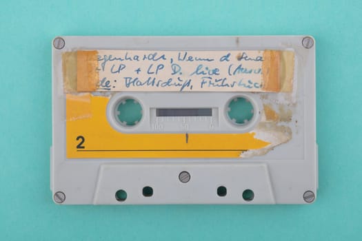 Self -Labeld old used audio tape isolated over green Background