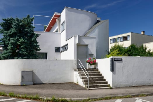 view, from the public street, of the house built in twenties by the famous architect in the residential quarter established according to the standards of modern architecture, shot in sunny weather