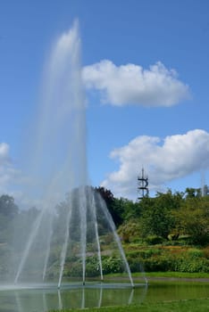 Stuttgart, Germany, 2012 july 22th, high water jet in fountain in the park, in background the steel structure of the panoramic tower..